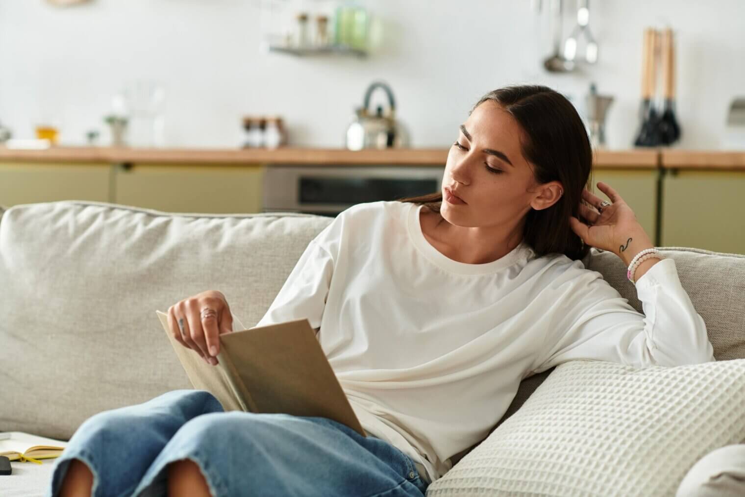 person reading a book on a couch